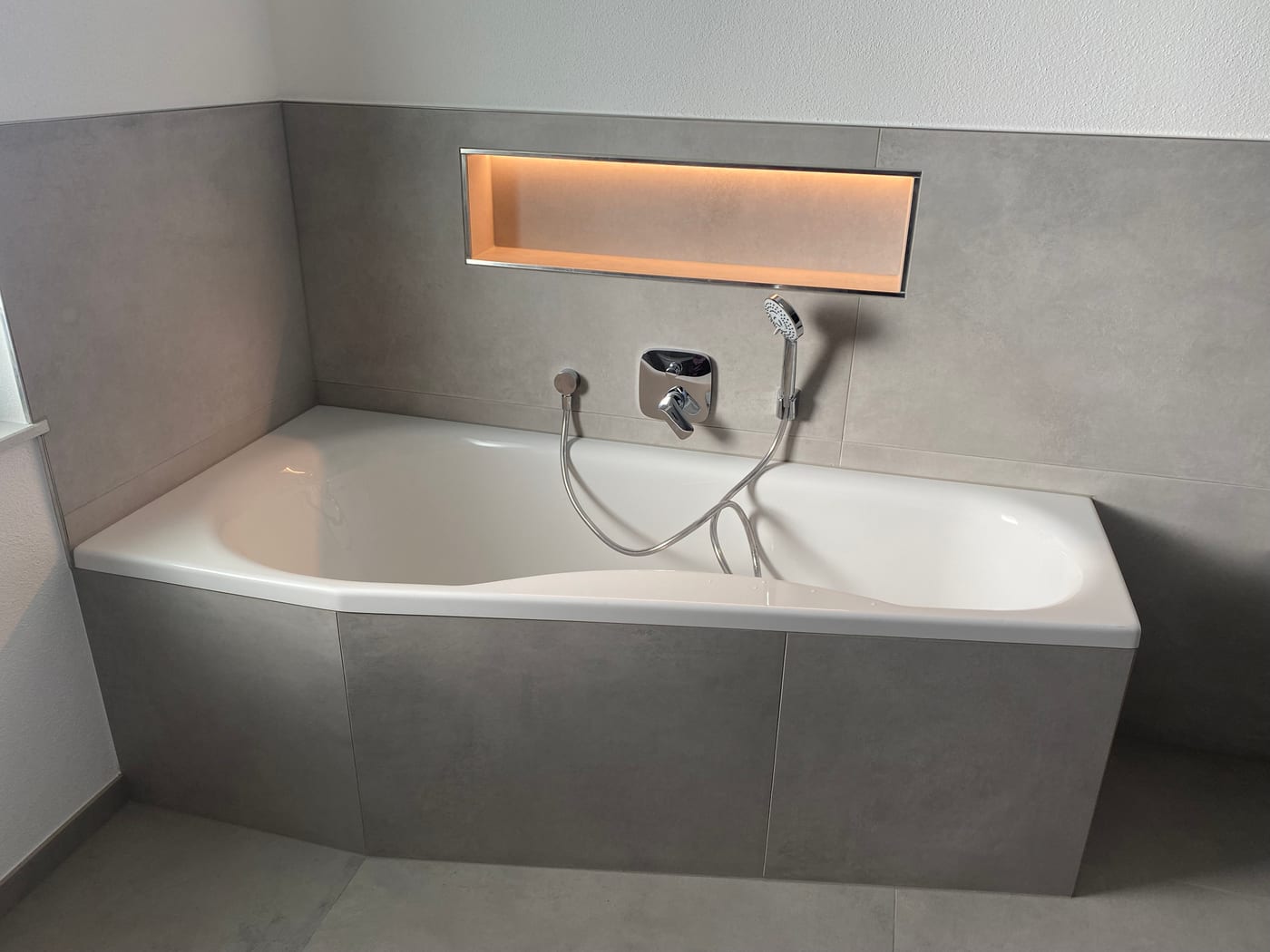 Komplette Badsanierung mit Eckbadewanne und beleuchteter Wandnische